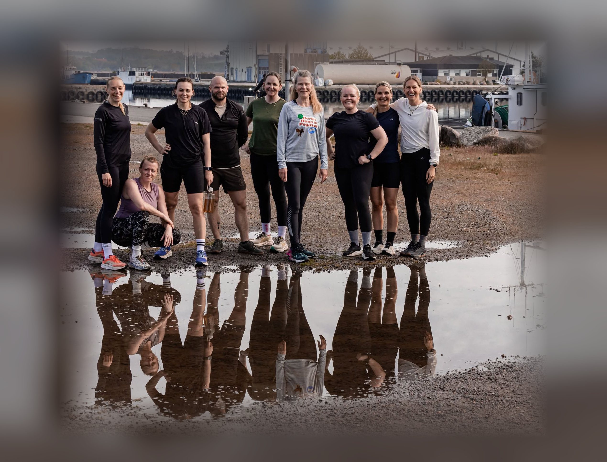 Holdet samlet på havnen i Nexø, spejlet i en vandpyt